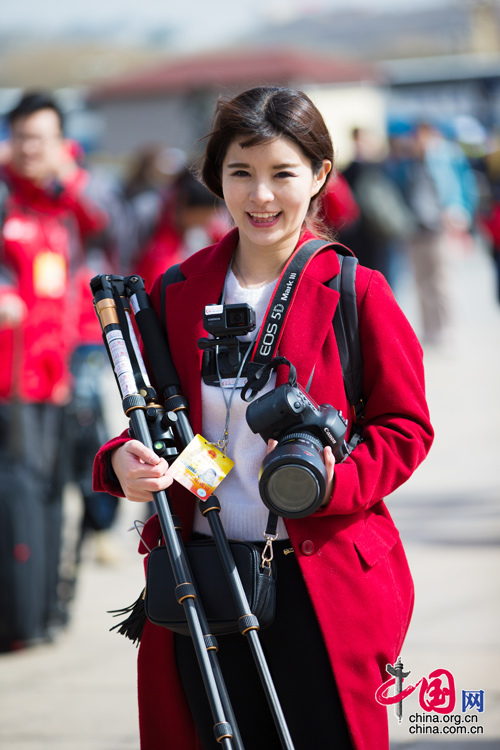 2016年兩會，人民大會大堂前，一位笑容燦爛的紅衣女記者正步入大會堂。中國網(wǎng) 鄭亮 攝