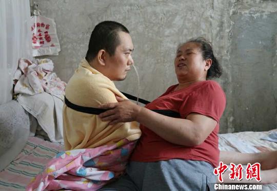身體日漸衰老的梁青蘭每次幫兒子翻身、坐立，全身的衣物都要濕透一次?！∩忻鱾b 攝