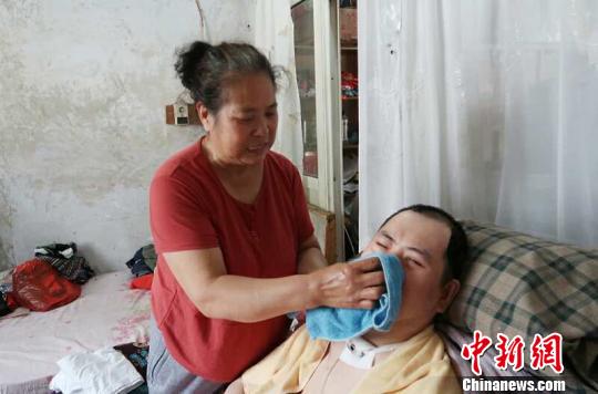 每次喂完食物后，梁青蘭都要仔細(xì)地幫兒子清理干凈。　尚明俠 攝
