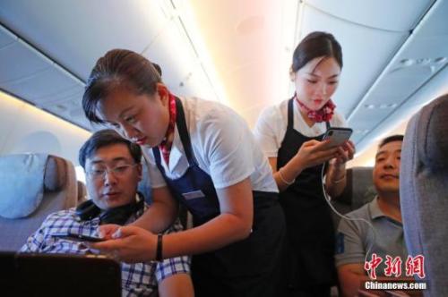 資料圖：乘務(wù)員們在客艙內(nèi)為旅客調(diào)試機(jī)上上網(wǎng)功能。<a target='_blank' ><p  align=