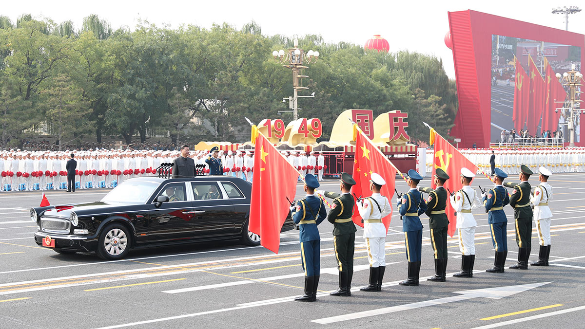 習(xí)近平驅(qū)車行進(jìn)至黨旗、國旗、軍旗前，向旗幟行注目禮