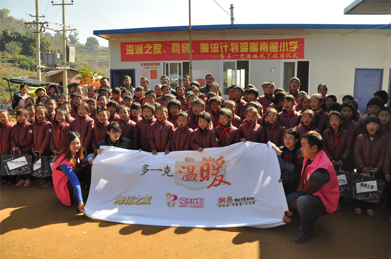 2014年11月20日，“多一克溫暖”公益團(tuán)隊(duì)來到8.3大地震的重災(zāi)區(qū)——云南省昭通市魯?shù)榭h的南筐小學(xué)。越過崎嶇山路，將一批又一批暖心羽絨服送到了師生們的手中，也將社會的關(guān)懷和愛意傳遞給了這些可愛的人。