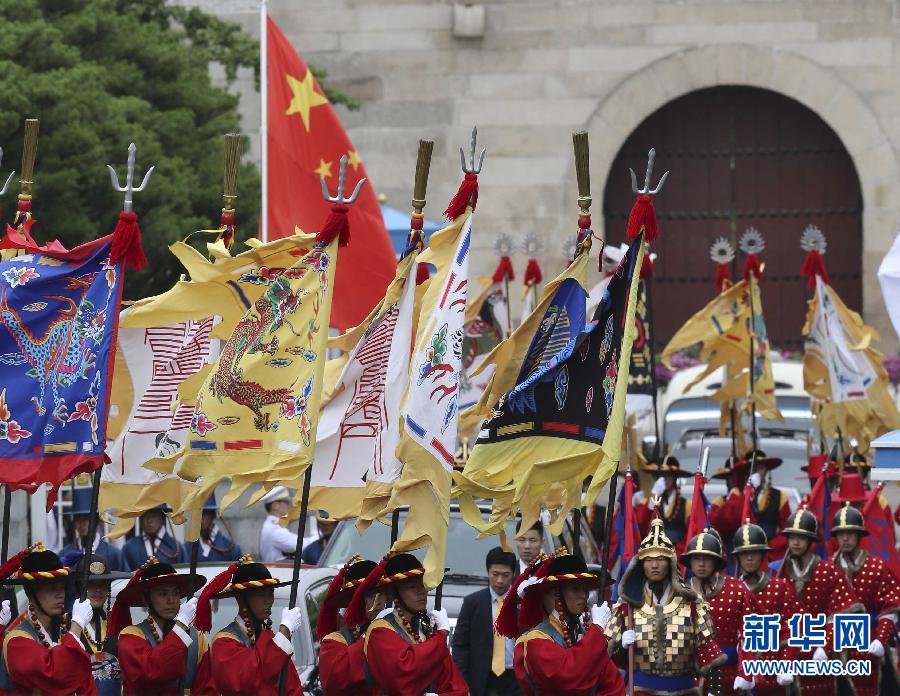 7月3日，韓國(guó)總統(tǒng)樸槿惠在青瓦臺(tái)總統(tǒng)府舉行隆重儀式，歡迎中國(guó)國(guó)家主席習(xí)近平對(duì)韓國(guó)進(jìn)行國(guó)事訪問(wèn)。這是習(xí)近平的車隊(duì)在身著民族服裝的韓國(guó)禮儀隊(duì)伍引導(dǎo)下駛?cè)肭嗤吲_(tái)。新華社記者丁林?jǐn)z  